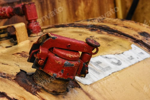 Preview: Closeup shot of a red valve of a diesel fuel yellow tank with blur background