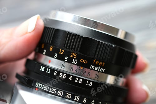 Preview: Changing settings on a vintage retro SLR camera lens - photography concept