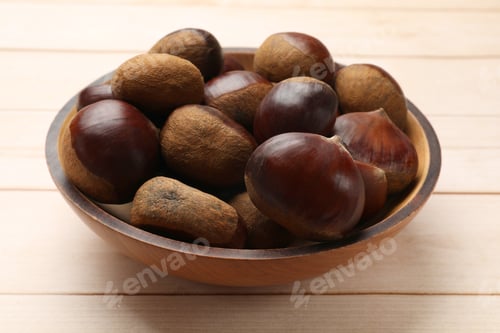 Preview: Sweet fresh edible chestnuts on light wooden table, closeup