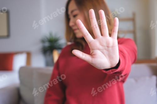 Preview: Closeup image of a woman outstretched hand and showing stop hand sign