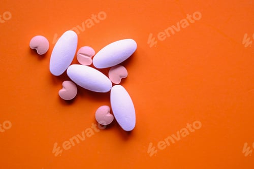 Preview: A Colorful Assortment of Pills Displayed Against a Bright Orange Background Surface
