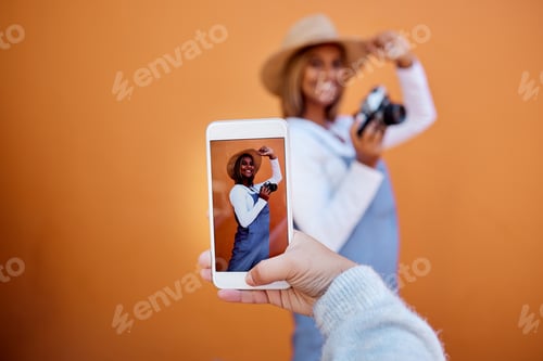 Preview: Friends taking picture on a phone of woman isolated on wall background on social media or digital m