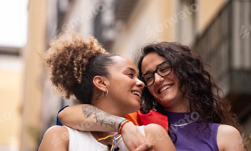 Preview: Headshot of two multiethnic lesbian women in love hugging and smiling enjoying time together
