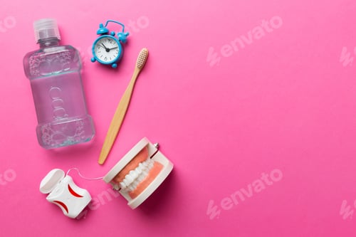 Preview: Mouthwash and other oral hygiene products on colored table top view with copy space.