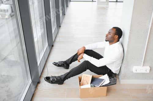 Preview: Sad african american businessman sitting on office building