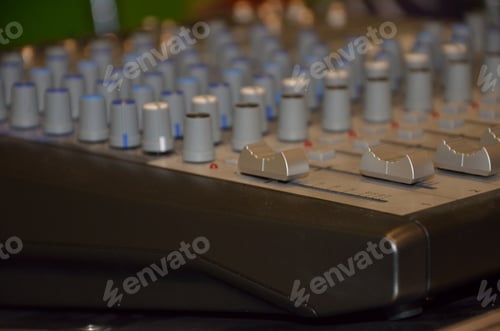 Preview: Professional audio mixing console with faders and adjusting knobs.