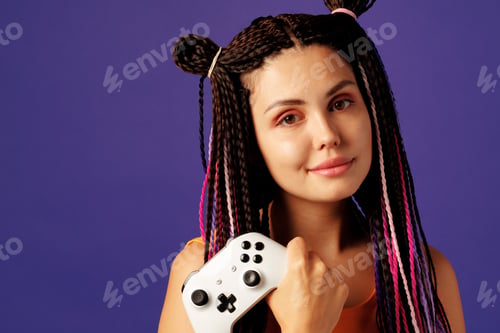 Preview: Cool young caucasian woman with colorful braids playing video games close-up