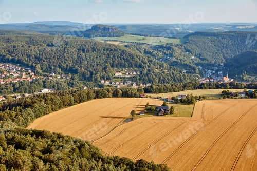 Preview: aerial view of agricultural fields near village and mountains in Bad Schandau, Germany