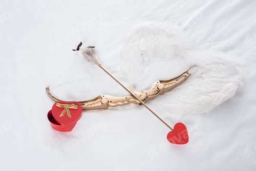 Preview: top view of gift box, wings, bow and arrow on white bed