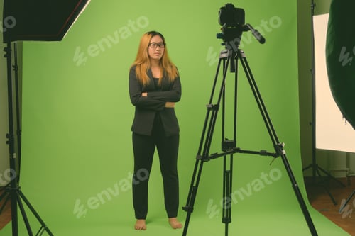 Preview: Young Asian businesswoman against green background