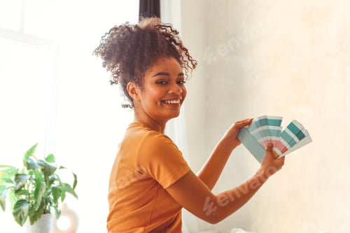 Preview: Smiling African American girl stands back to camera in middle of bed room with palette