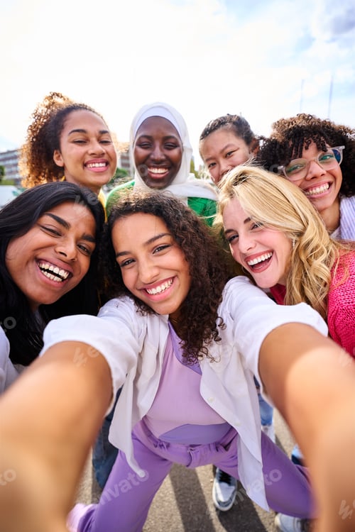 Preview: Large group of young smiling multiracial only women taking selfie photo looking at camera outdoor