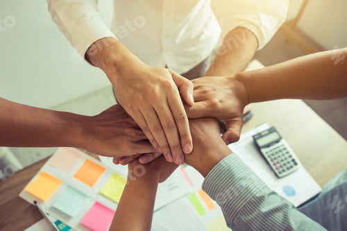 Preview: Close up of group of business people joining their hands together in unity.