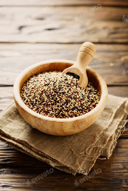 Preview: Mix of raw red, white and black quinoa on thw wooden table