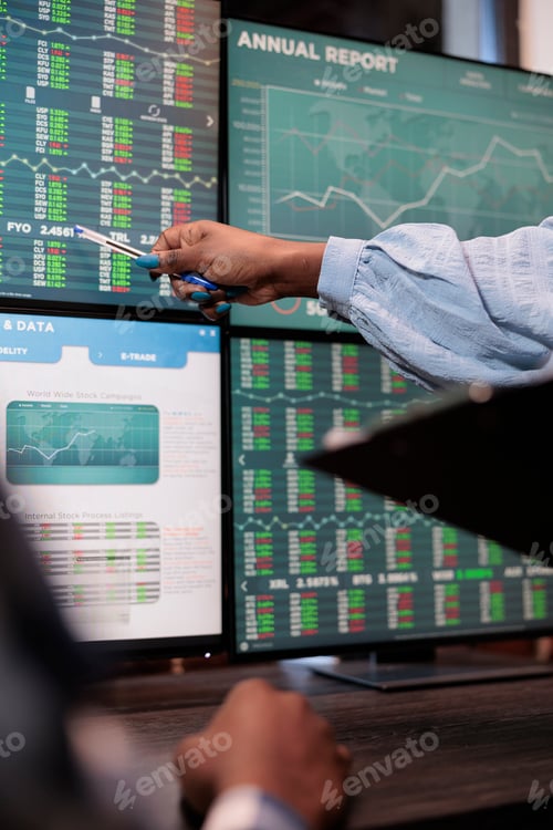 Preview: Close up shot of financial advisor pointing out downtrend of market while reviewing real time data