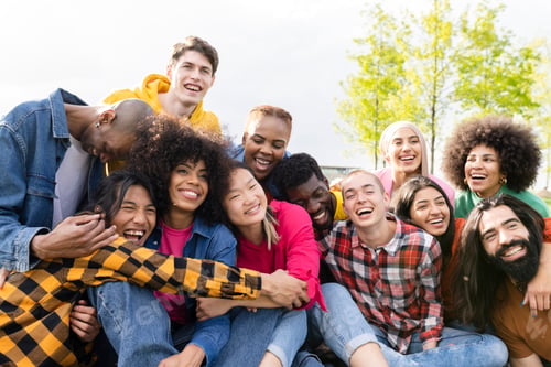Preview: group of multiracial friends having picnic having fun in city park at sunset.