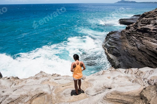 Preview: Woman exploring rocky coast, Spitting Caves, Oahu, Hawaii