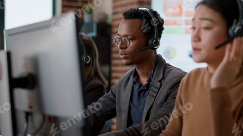Preview: Male call center operator using headset to help people