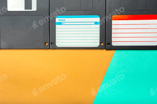 Preview: Old computer floppy disks on a colorful background with paper