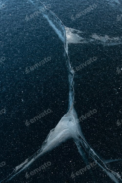 Preview: Natural blue ice on the lake. Beautiful winter landscape. Cracks in the ice. Frozen lake surface.