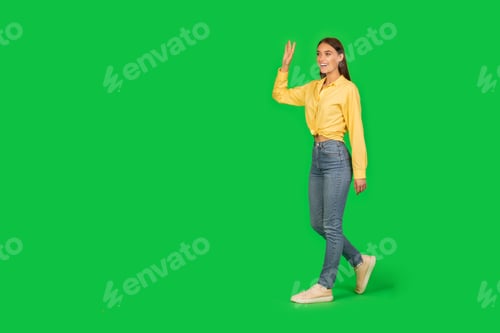 Preview: Cheerful Lady Walking Waving Hand Over Green Studio Background