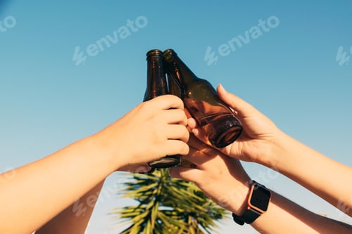 Preview: Closeup shot of bottles lifted high on blue sky background