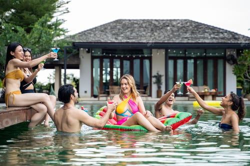 Preview: Group of diverse friend drinking alcohol, having a pool party together.