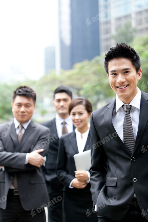 Preview: Cheerful businessman with his team in Hong Kong