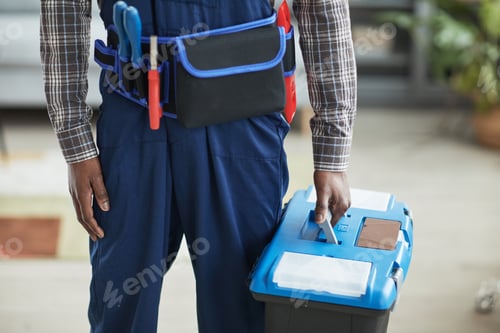 Tradesman in Blue Overalls Holding a Toolbox