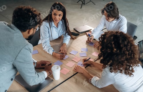 Preview: Office workers are by the table with paper stickers, brain storming