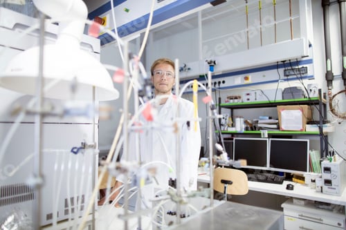 Preview: Portrait of young male scientist behind lab experiment