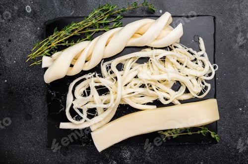 Preview: Assortiment of Traditional Caucasian Chechil white cheese on black board, top view.