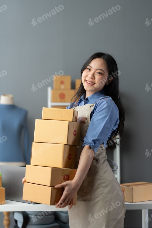Preview: Start up small business entrepreneur SME or freelance asian woman using laptop with box, Young succe