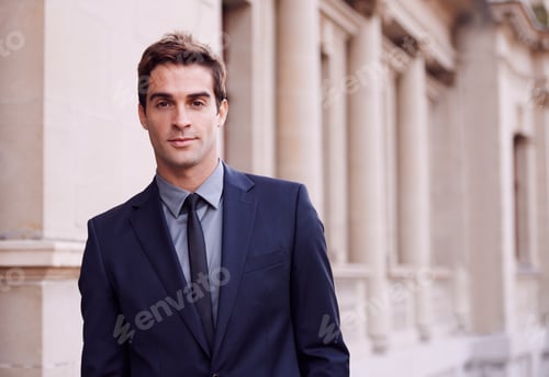 Young Man in Suit Poses Near Columns