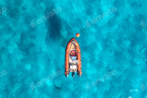 Preview: Aerial view of beautiful orange boat in blue sea at sunset