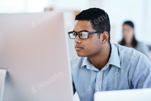 Preview: Shot of a young businessman using a computer in a modern office