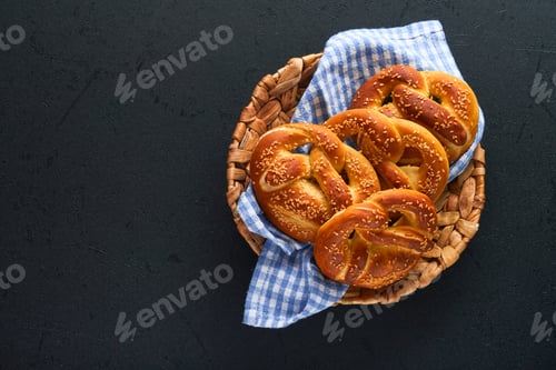 Preview: Bavarian pretzels and glass of lager beer. Oktoberfest food menu, traditional salted pretzels on bla