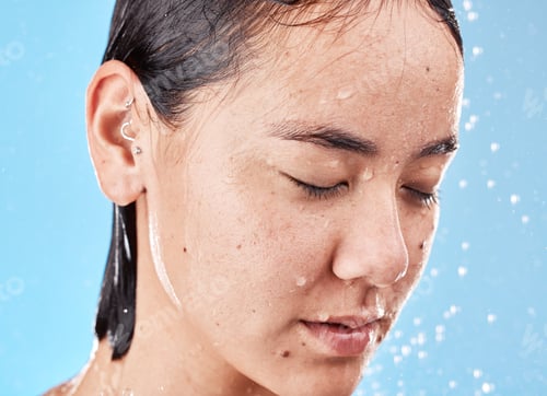 Preview: Calm, water and woman in the shower for grooming, hygiene and relax against a blue studio backgroun