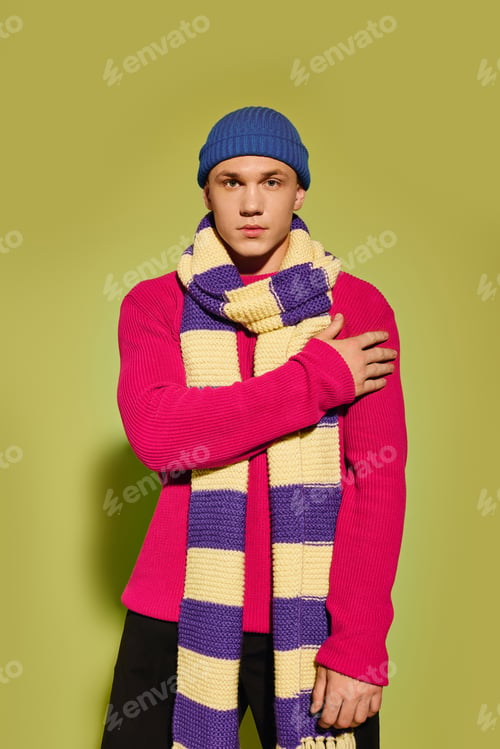 Preview: Young man showcases vibrant fashion style in a trendy studio setting