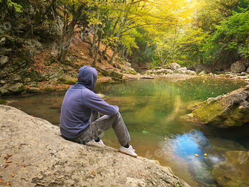 Preview: Man in autumn forest and river.