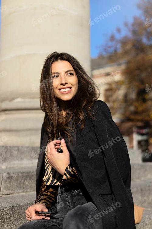 Preview: Portrait of a beautiful, smiling woman sitting on the stairs. A young girl poses and looks away.