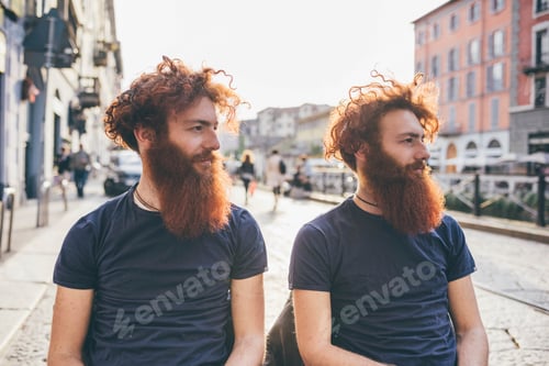 Preview: Young male hipster twins with red hair and beards on city street