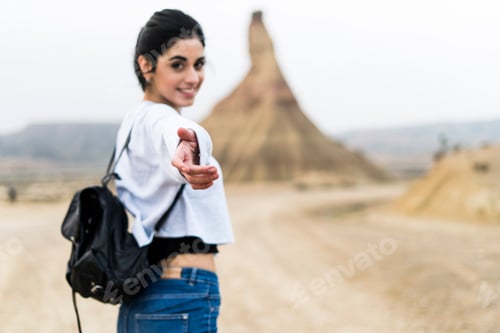 Preview: Spain, Navarra, Bardenas Reales, smiling young woman reaching out her hand to viewer