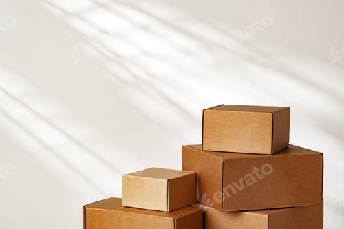 Preview: Stacked Cardboard Boxes On Wooden Surface In Sunlight