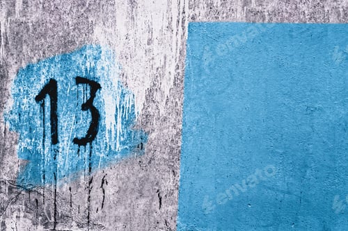 Preview: Number 13 painted on dirty concrete wall on the corner of old abandoned house