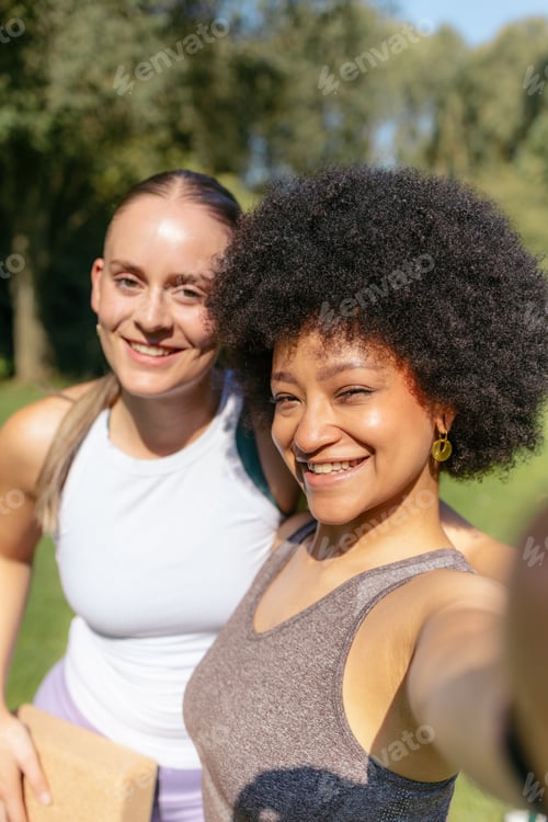 Preview: Smiling diverse women posing for selfie in activewear outdoors