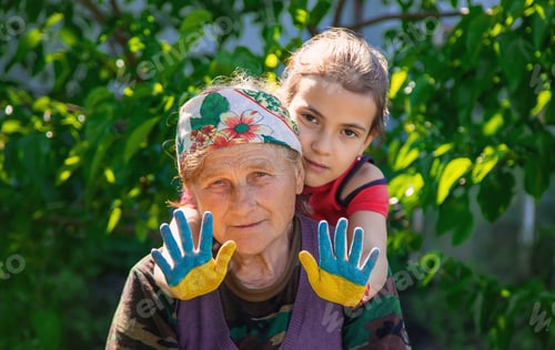 Preview: Child and grandmother hand drawn flag of Ukraine. Selective focus.