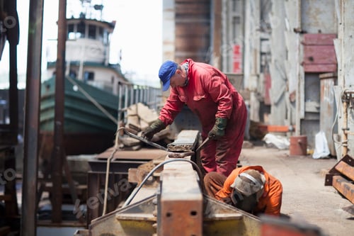 Preview: Workers engaged in shipyard maintenance