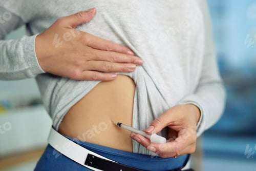 Preview: Closeup shot of an unidentifiable businesswoman injecting her stomach