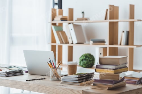Preview: laptop and educational books on table in light interior